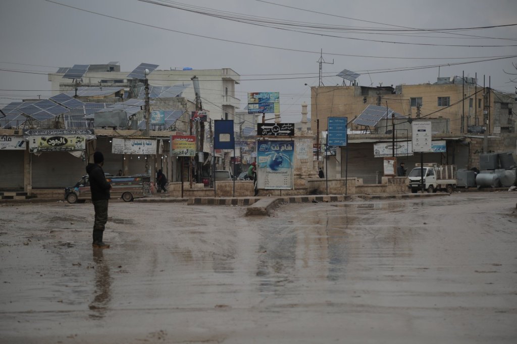 A man stands in the main square of the village of Atmeh in northwest Syria, where shops close their doors before the Zuhr prayer (MEE/Bilal al-Hammoud)